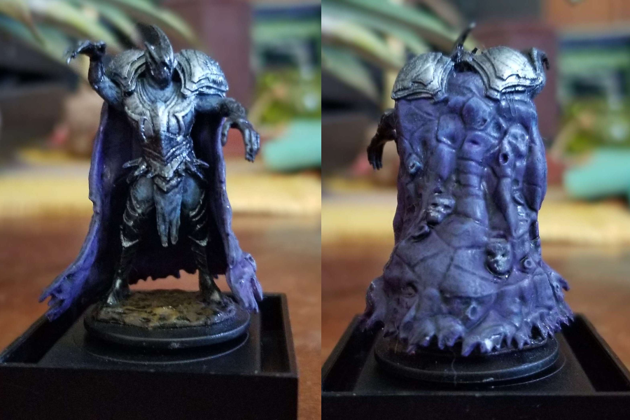 A dark figure in sharp, pointed grey armor and a purple cloak with spectral faces.