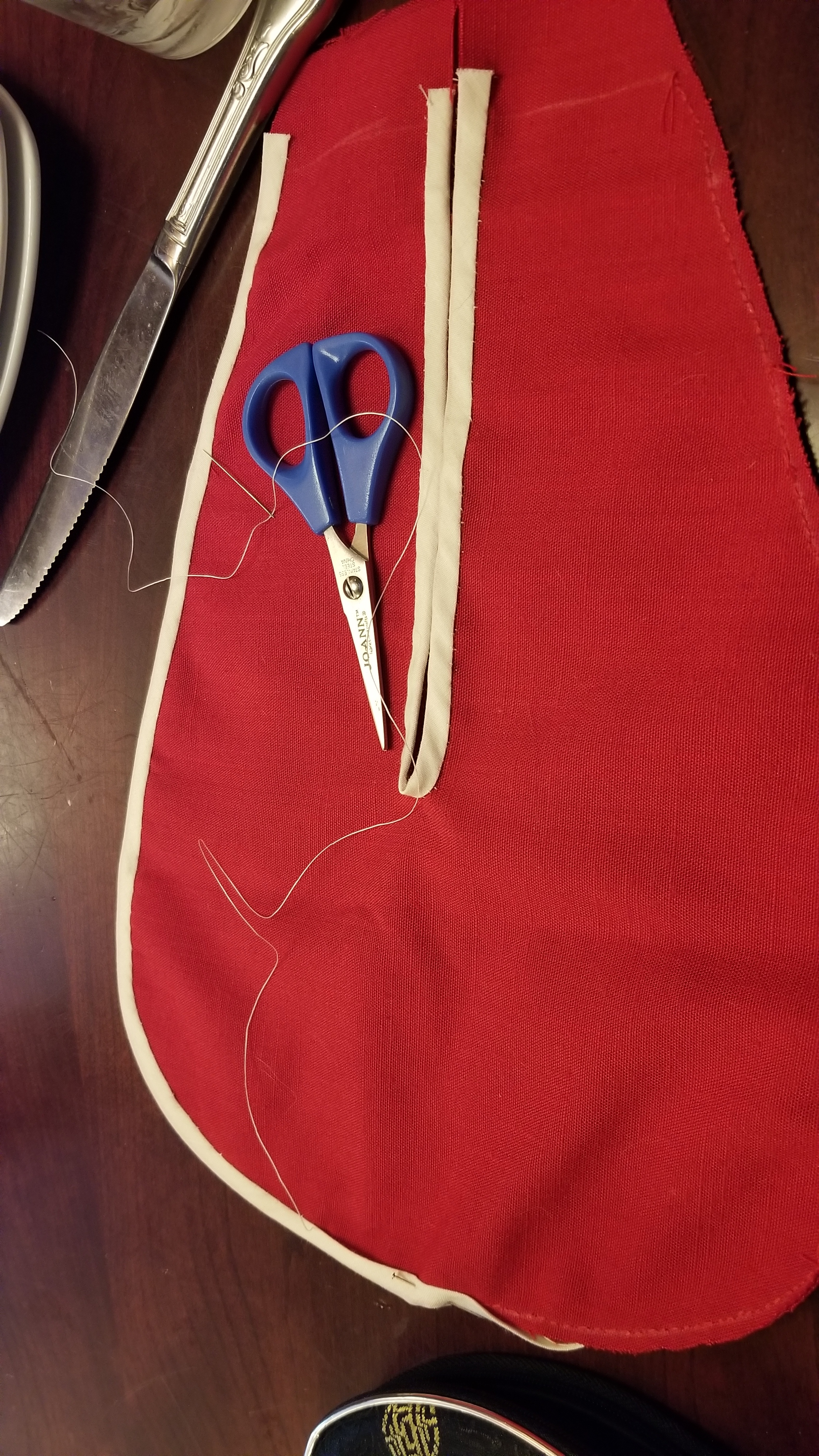 A partially sewn 18th century pocket being made from red-linen.